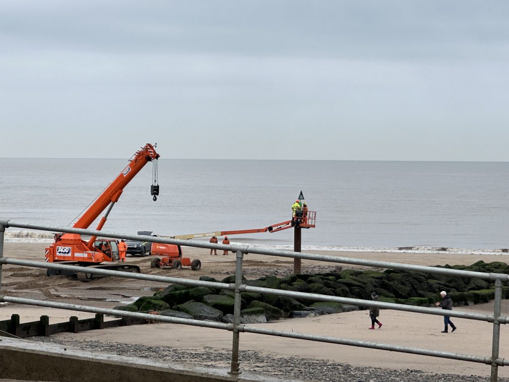 Fitting a green warning triangle to the top of a new groyne marker pole